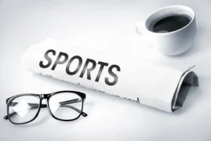 Очки, чашечка кофе и газета со спортивными новостями